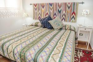 a bedroom with a bed with a colorful comforter and pillows at La Dimora Di Odisseo in Trapani