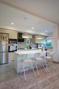 a kitchen with a white counter and two chairs at Casa Emon Cascais New Mordern Apartment 3 Bedrooms in Cascais