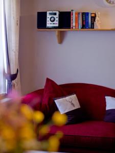um sofá vermelho com almofadas e uma prateleira com livros em Ferienlandhaus Brunner em Zachenberg