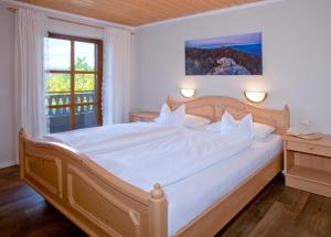 Schlafzimmer mit einem großen weißen Bett und einem Fenster in der Unterkunft Ferienlandhaus Brunner in Zachenberg