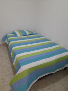 - un lit avec une couette colorée à rayures et 2 oreillers dans l'établissement Casa hotel hispania 2, à Hispania