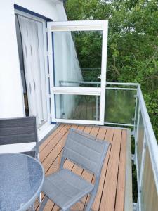 a deck with two chairs and a table and a window at Ferienwohnung: Utkiek in Langeoog