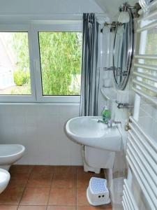 ランゲオークにあるFerienwohnung: Utkiekのバスルーム(洗面台、トイレ付)、窓が備わります。