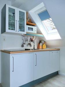 a kitchen with white cabinets and a sink at Ferienwohnung: Utkiek in Langeoog