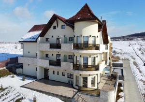 una vista aerea di una casa nella neve di Pensiunea Palace a Baile Felix