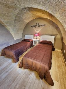 two beds in a room with an attic at B&B Duca Orsini in Gravina in Puglia