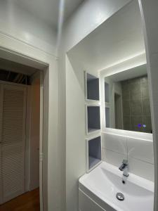 uma casa de banho branca com um lavatório e um espelho em 1 Bed Apartment (sleeps 4) on Leith Walk em Edinburgo