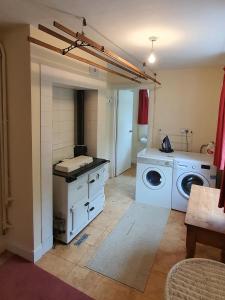 eine Küche mit einer Waschmaschine, einer Waschmaschine und einem Trockner in der Unterkunft Wey House in Withypool