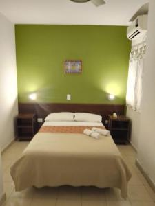 a bedroom with two beds with a green wall at HOTEL SIENa in Buenos Aires