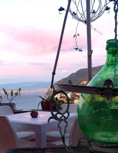 eine grüne Glasflasche auf einem Tisch in der Unterkunft Dimora del Conte Sorrento coast seaview in Vico Equense