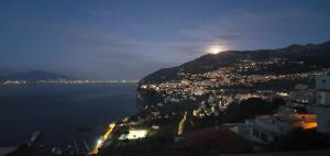 einen Blick auf eine Stadt in der Nacht mit dem Mond auf einem Berg in der Unterkunft Dimora del Conte Sorrento coast seaview in Vico Equense