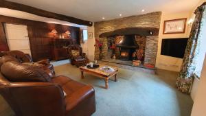 a living room with a couch and a fireplace at Wey House in Withypool