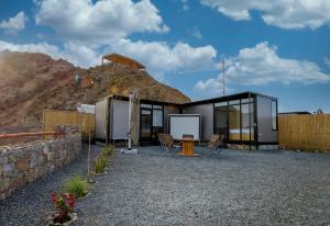 une maison sur une colline avec un mur en pierre dans l'établissement Go Camp Mountain Nature Lodge مخيم الطبيعة الجبلية, à Sharīyah