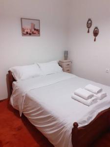 Un dormitorio con una cama blanca con toallas. en Christos Home, en Pramanta