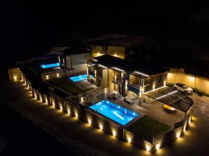 a house with a swimming pool at night with lights at Mani Theasis in Stoupa