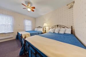 1 dormitorio con 2 camas y ventilador de techo en The Pines Inn, en Lake Placid