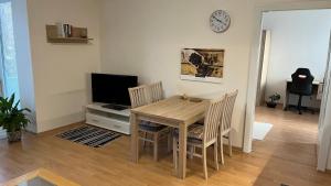 a dining room table with two chairs and a television at V srdci mesta in Gerlachov