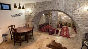 een kamer met een tafel en een stenen muur bij Palace of Sultan Jalal Basha in Abū Ghaush