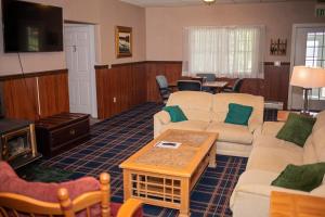 uma grande sala de estar com sofás e uma televisão em Longhouse Manor B&B em Watkins Glen