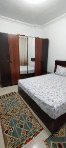 1 dormitorio con cama, espejo y alfombra en Doudy en Sharm El Sheikh