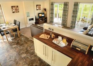 a living room with a couch and a table and a kitchen at Tydd St Giles Resort in Wisbech