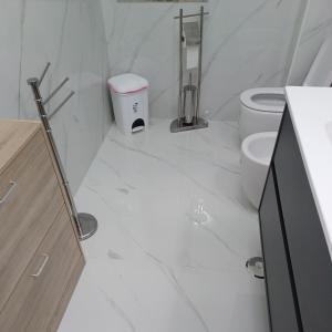 La salle de bains blanche est pourvue de toilettes et d'un lavabo. dans l'établissement B&B La Colonna, à Crotone