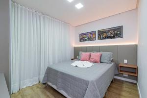 1 dormitorio con 1 cama con almohadas rosas y azules en Apto Maestria - Stay House, en Gramado