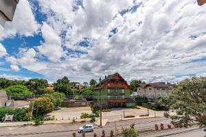 um edifício numa rua com um céu nublado em Apto Maestria - Stay House em Gramado