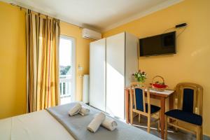 a bedroom with a bed and a table and a tv at Apartmani Niki ZVEKOVICA in Cavtat