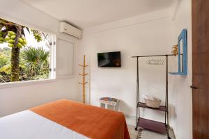 a bedroom with a bed and a window at Casa Amarela in Angra dos Reis