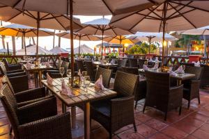 un restaurante con mesas, sillas y sombrillas en Holiday Inn Resort Ixtapa All-Inclusive, an IHG Hotel en Ixtapa