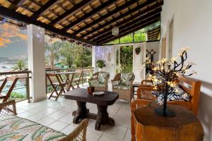 a living room with a table and chairs on a patio at Casa Amarela in Angra dos Reis