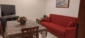 a living room with a red couch and a table at Appartamento da Miriam in Lido di Ostia
