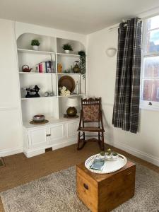 a living room with a chair and a wooden table at Ashcroft Hall - Converted Chapel in Central Cirencester in Cirencester