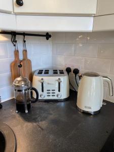 a kitchen counter top with a toaster and a toaster and a slow cooker at Ashcroft Hall - Converted Chapel in Central Cirencester in Cirencester