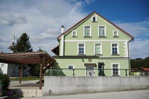 una casa verde con una valla delante en Hostel Mladinski center Šmartno ob Paki en Šmartno ob Paki