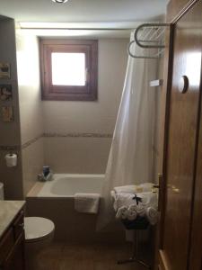 uma casa de banho com uma banheira, um WC e um lavatório. em Paso del Onso em Escarrilla