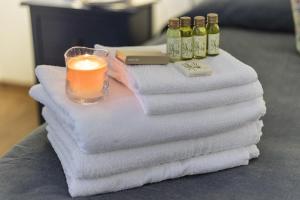 a pile of towels with a candle and bottles of wine at La Dimora Di Odisseo in Trapani +59 photos