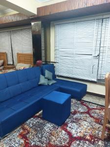 a blue couch in a living room with a rug at شقة فندقية بجوار محطة مترو الدقي in Cairo