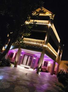 un edificio con luces moradas en él por la noche en مون لايت Moon Light Villa, en ‘Ezbet Sa‘dî Mugâwir