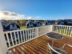 balcón con mesa, sillas y casas en Wounderful holiday house with wifi, spa & sauna, en Gjern