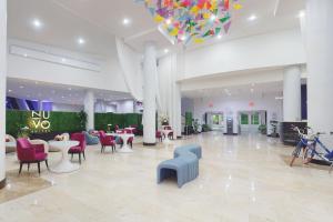 a lobby with tables and chairs and a chandelier at Nuvo Suites Hotel - Miami Doral in Miami