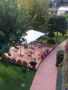 een patio met tafels en stoelen en een witte parasol bij Farfalle E Gabbiani in Tramonti