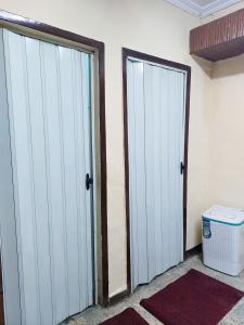 two sliding doors in a room with a trash can at شقة فندقية بجوار محطة مترو الدقي in Cairo