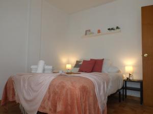 een slaapkamer met een groot bed met rode kussens bij Encantadora casa Benajarafe in Benajarafe