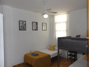 een witte kamer met een bed en een piano bij Encantadora casa Benajarafe in Benajarafe