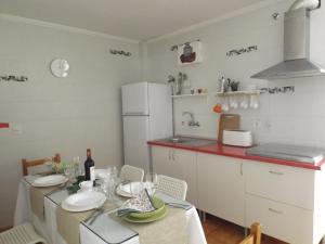 een keuken met een tafel en een witte koelkast bij Encantadora casa Benajarafe in Benajarafe