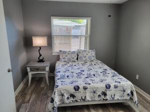 ein Schlafzimmer mit einem Bett, einer Lampe und einem Fenster in der Unterkunft WaterFront Mid Century Cottage - Close to beach - 2 BR 3 BA in Ruskin