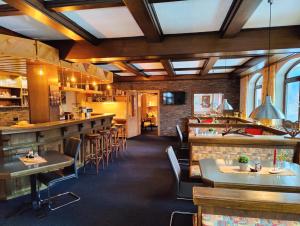un ristorante con bar e alcuni tavoli e sedie di Pension Almhof ad Afritz