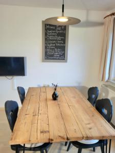 a wooden table with chairs and a blackboard on the wall at Wohnung Weitsicht Ruhpolding, 3 Schlafzimmer, Bergpanorama, Alleinlage in Ruhpolding